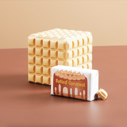Stack of salted caramel candy bars with packaging on a brown background