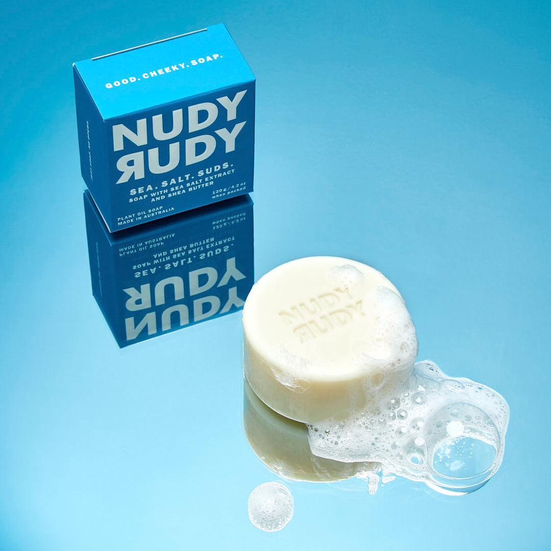Nudy Rudy soap bar with packaging on a blue background